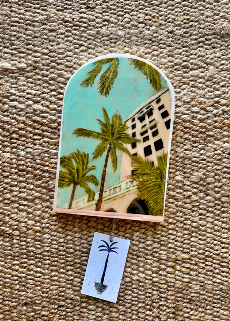 A decorative arch-shaped ceramic tile with a vibrant tropical hotel scene, including palm trees and the hotel national in havana