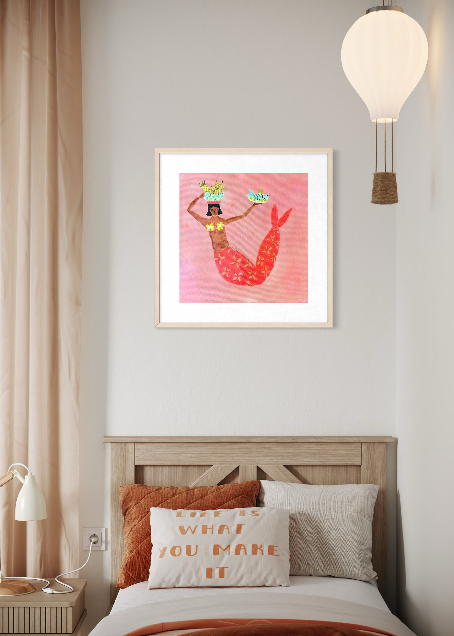 Framed artwork of a mermaid on a wall above a bed with decorative pillows.