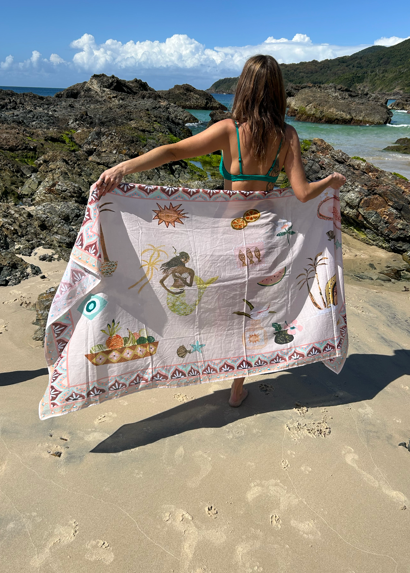 Woman holding sea song sarong by sue fantini on a beach
