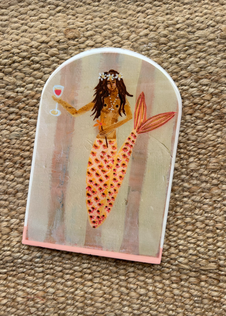 Decorative item with a mermaid design on a textured surface