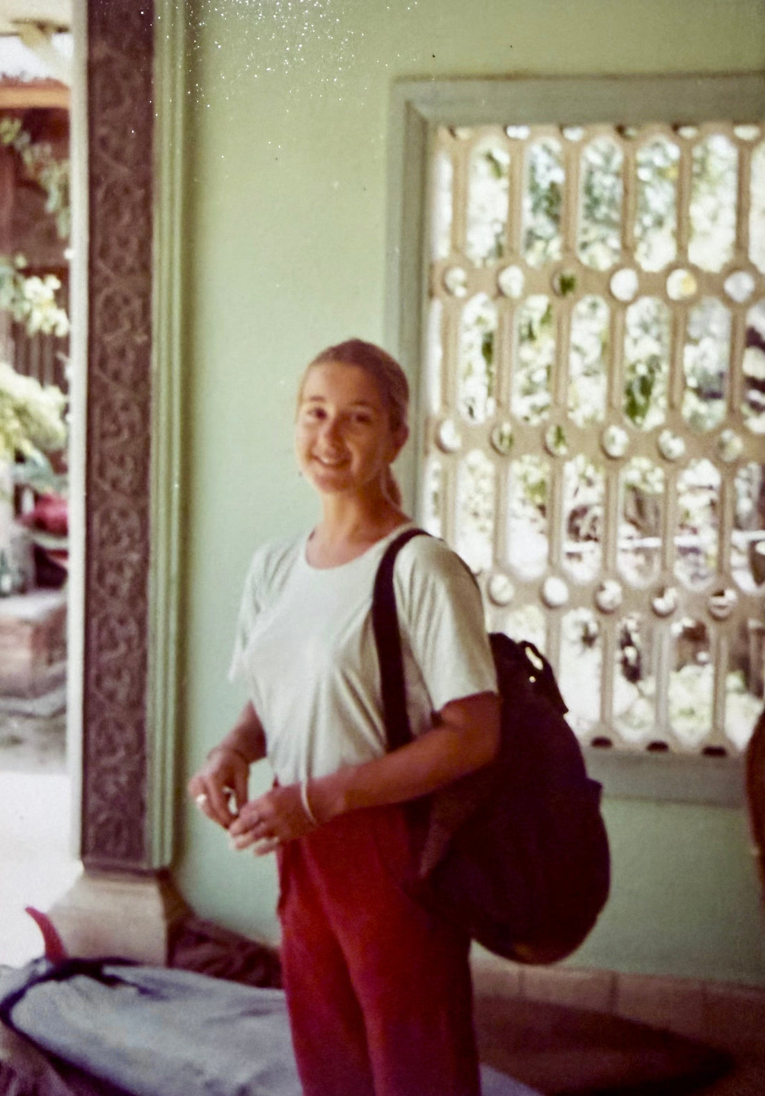 Young Sue Fantini with backpack and board on the ground