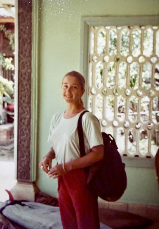 Young Sue Fantini with backpack and board on the ground