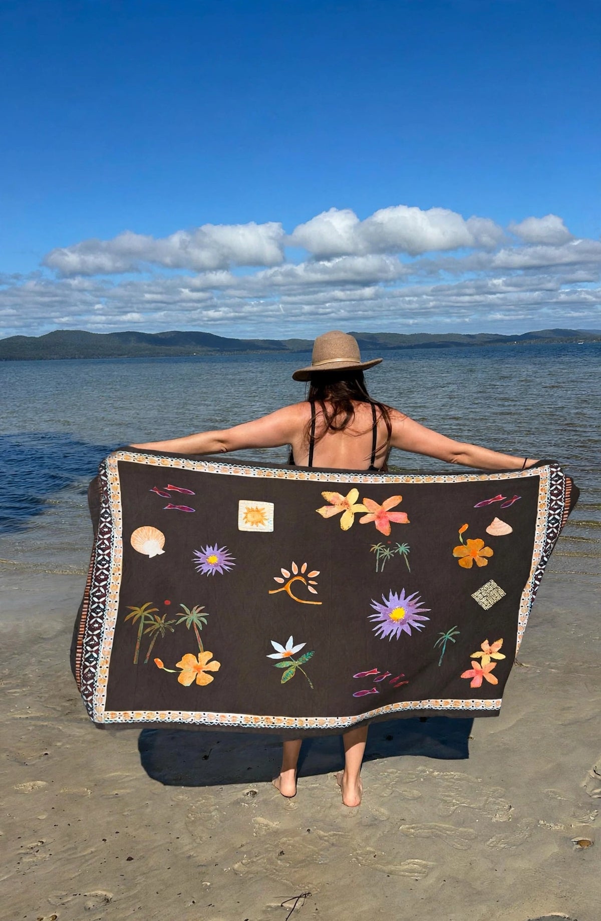 Girl holding sarong on beach