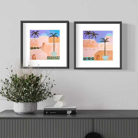 Set of two Moroccan prints in peach, pink, violet and olive framed on wall with buffet and plant